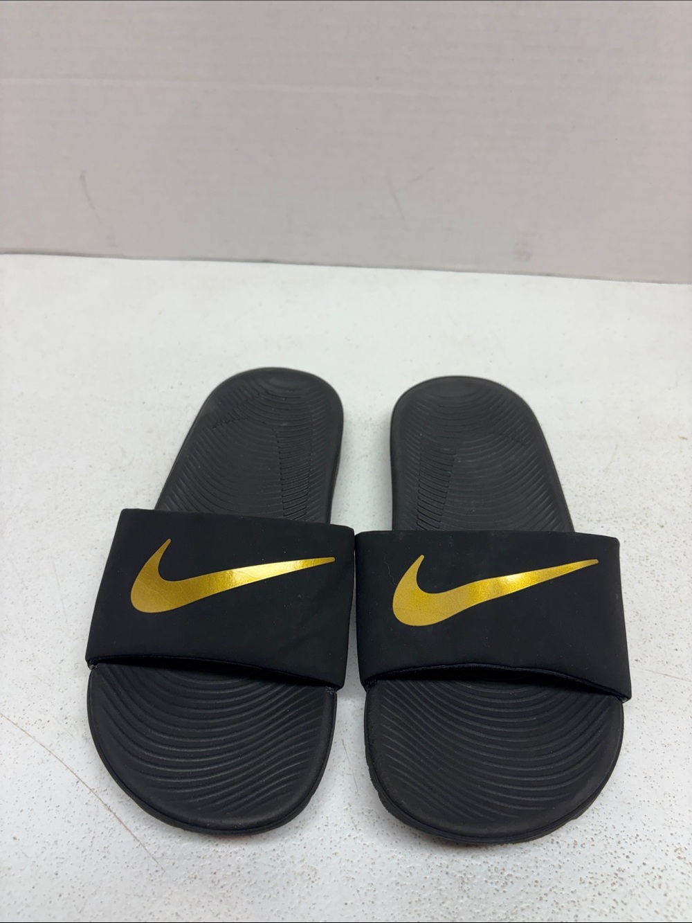 Nike Black Slides with Gold Swoosh Detail